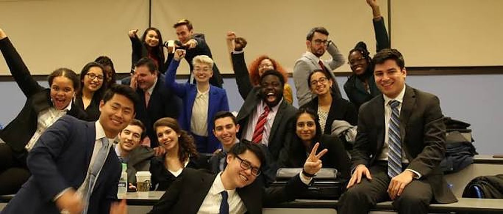 A large group of students celebrating together in a lecture hall